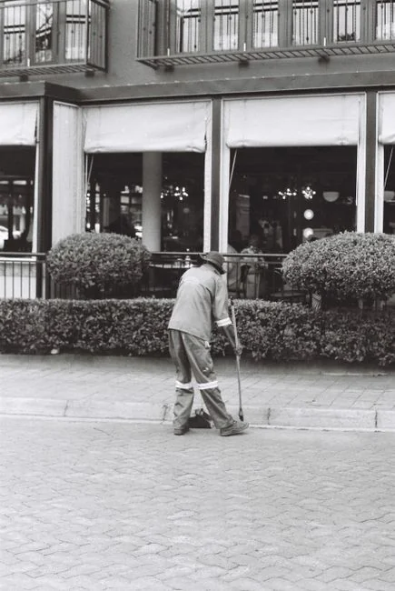 Un employé nettoyant les vitres d’un gratte-ciel avec un harnais, dans un cadre urbain.